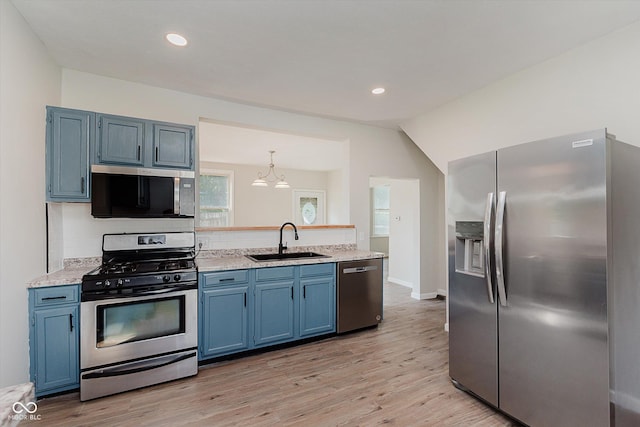 312 E Columbia St, Attica, IN 47918 - kitchen with appliances with stainless steel finishes, blue cabinetry, light countertops, light wood-style floors, and a peninsula