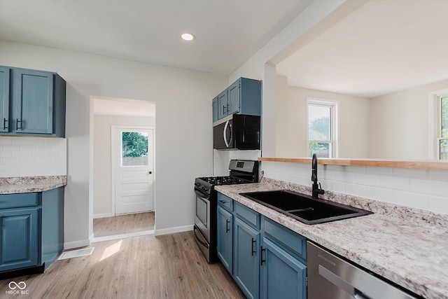 312 E Columbia St, Attica, IN 47918 - kitchen with stainless steel appliances, blue cabinetry, decorative backsplash, plenty of natural light, and recessed lighting