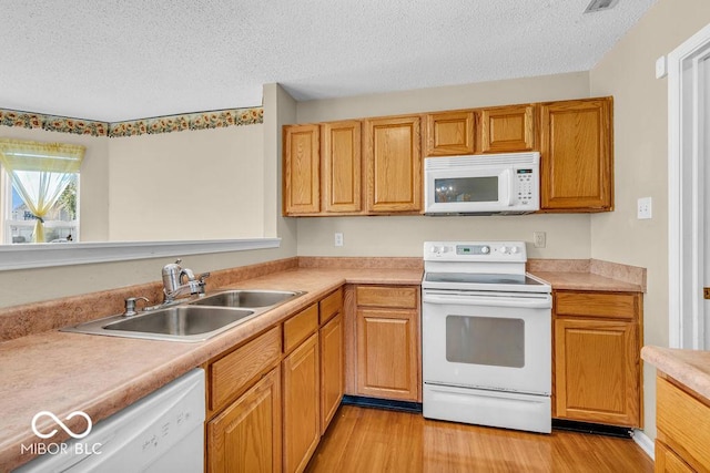 5971 Portman Pl, Plainfield, IN 46168 - kitchen with white appliances, light wood-style flooring, a textured ceiling, and light countertops