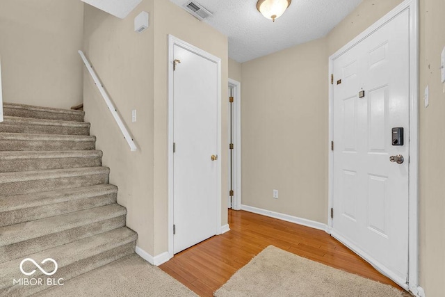 5971 Portman Pl, Plainfield, IN 46168 - foyer featuring wood finished floors, stairs, and a textured ceiling