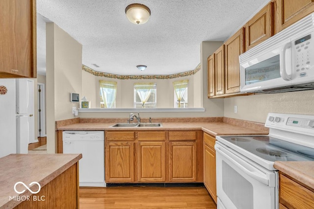 5971 Portman Pl, Plainfield, IN 46168 - kitchen featuring white appliances, light countertops, light wood-style flooring, a textured ceiling, and brown cabinets