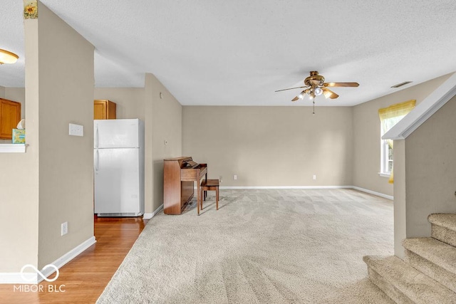 5971 Portman Pl, Plainfield, IN 46168 - unfurnished living room with a ceiling fan, stairs, light carpet, and light wood-style flooring