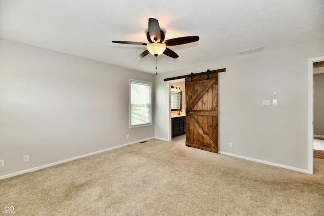 3675 Homestead Cir E, Plainfield, IN 46168 - unfurnished bedroom with a barn door, light colored carpet, ensuite bath, and ceiling fan