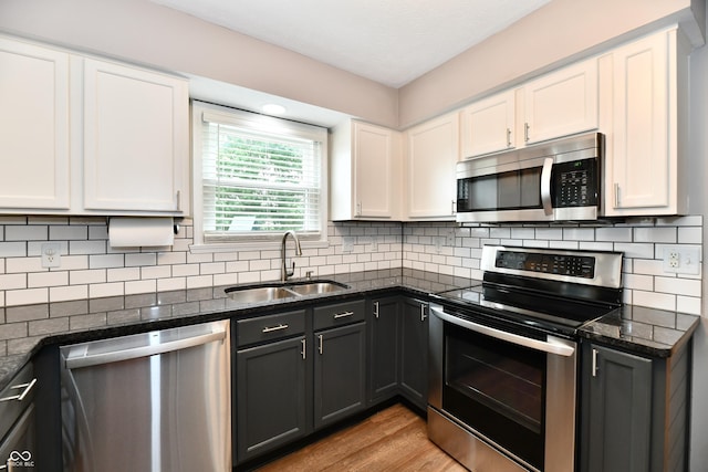 3675 Homestead Cir E, Plainfield, IN 46168 - kitchen featuring stainless steel appliances, white cabinets, backsplash, light wood-style flooring, and dark stone countertops
