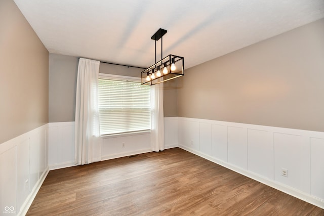 3675 Homestead Cir E, Plainfield, IN 46168 - empty room with wood finished floors, a wainscoted wall, a chandelier, and a decorative wall