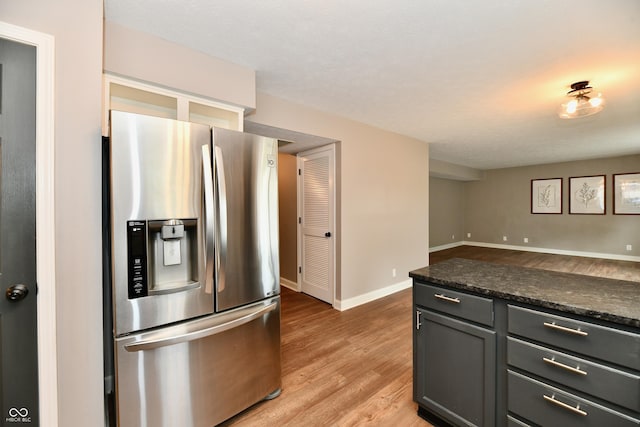 3675 Homestead Cir E, Plainfield, IN 46168 - kitchen with stainless steel fridge, light wood-style flooring, dark countertops, and gray cabinets