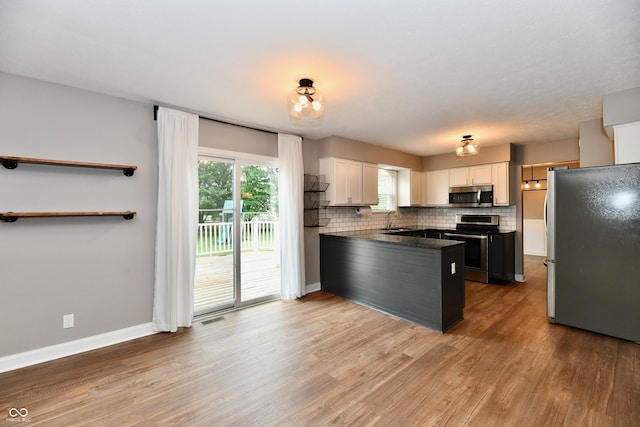 3675 Homestead Cir E, Plainfield, IN 46168 - kitchen featuring appliances with stainless steel finishes, wood finished floors, white cabinets, and decorative backsplash