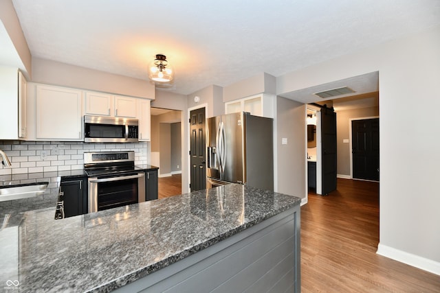 3675 Homestead Cir E, Plainfield, IN 46168 - kitchen featuring stainless steel appliances, dark stone counters, and wood finished floors