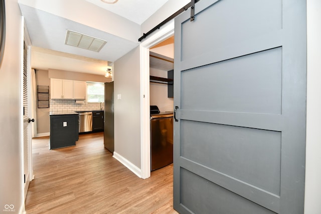 3675 Homestead Cir E, Plainfield, IN 46168 - hall with a barn door, light wood finished floors, and washer / clothes dryer