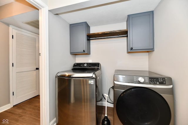 3675 Homestead Cir E, Plainfield, IN 46168 - laundry area featuring washing machine and dryer, wood finished floors, and cabinet space