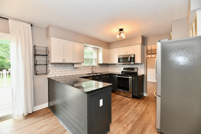 3675 Homestead Cir E, Plainfield, IN 46168 - kitchen featuring stainless steel appliances, a peninsula, white cabinets, and light wood-type flooring