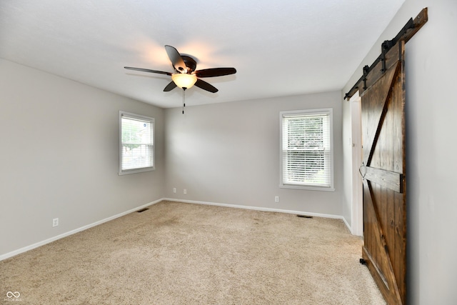3675 Homestead Cir E, Plainfield, IN 46168 - empty room with a barn door, healthy amount of natural light, a ceiling fan, and carpet floors