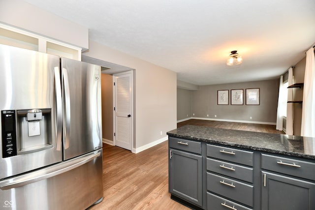 3675 Homestead Cir E, Plainfield, IN 46168 - kitchen with stainless steel fridge, light wood-type flooring, gray cabinetry, freestanding refrigerator, and dark countertops