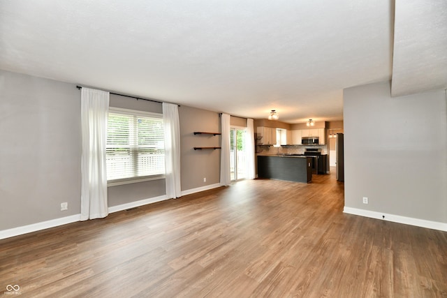 3675 Homestead Cir E, Plainfield, IN 46168 - unfurnished living room featuring wood finished floors and baseboards