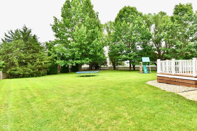 3675 Homestead Cir E, Plainfield, IN 46168 - fenced backyard featuring a trampoline, a playground, and a wooden deck
