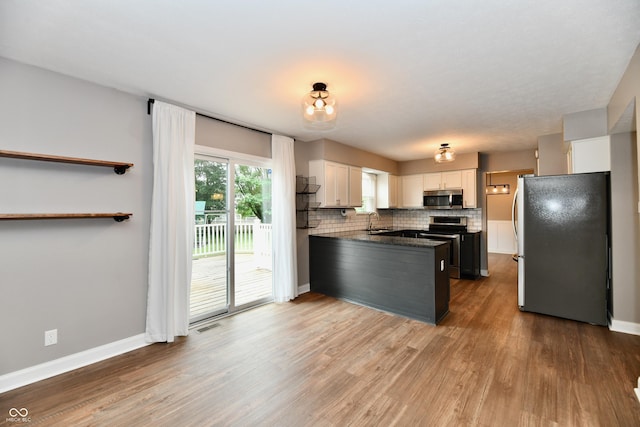 3675 Homestead Cir E, Plainfield, IN 46168 - kitchen featuring appliances with stainless steel finishes, white cabinets, wood finished floors, tasteful backsplash, and dark countertops