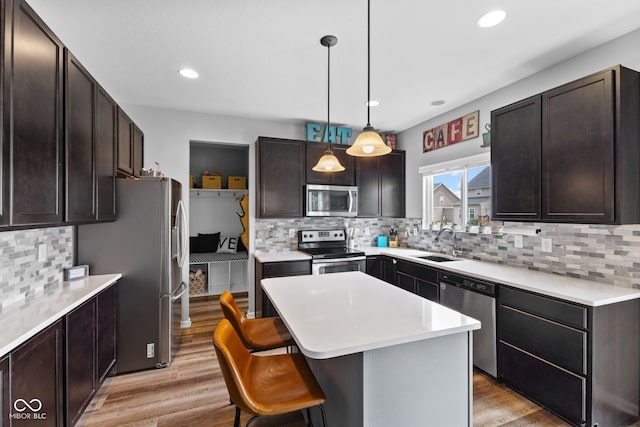 1425 Turkington Ct, Greenwood, IN 46143 - kitchen featuring appliances with stainless steel finishes, decorative backsplash, a kitchen breakfast bar, light countertops, and recessed lighting