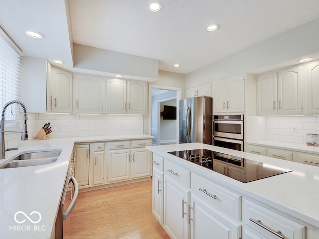 11668 Victoria Ct, Carmel, IN 46033 - kitchen with appliances with stainless steel finishes, recessed lighting, decorative backsplash, light wood-style floors, and white cabinetry