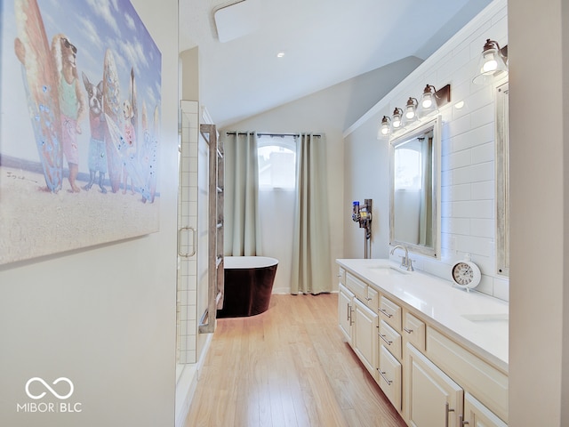 11668 Victoria Ct, Carmel, IN 46033 - full bath with wood finished floors, lofted ceiling, double vanity, a shower stall, and a freestanding tub
