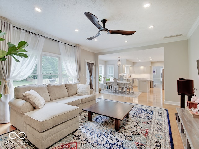 11668 Victoria Ct, Carmel, IN 46033 - living area with crown molding, plenty of natural light, recessed lighting, a ceiling fan, and light wood finished floors