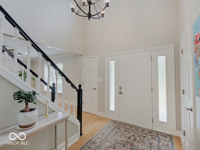 11668 Victoria Ct, Carmel, IN 46033 - entrance foyer with a high ceiling, light wood-style floors, stairway, and a chandelier