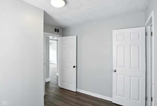 363 N 19th Ave, Beech Grove, IN 46107 - unfurnished bedroom with dark wood-type flooring and a textured ceiling