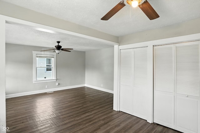 363 N 19th Ave, Beech Grove, IN 46107 - unfurnished bedroom featuring a textured ceiling, dark wood-type flooring, multiple closets, and a ceiling fan