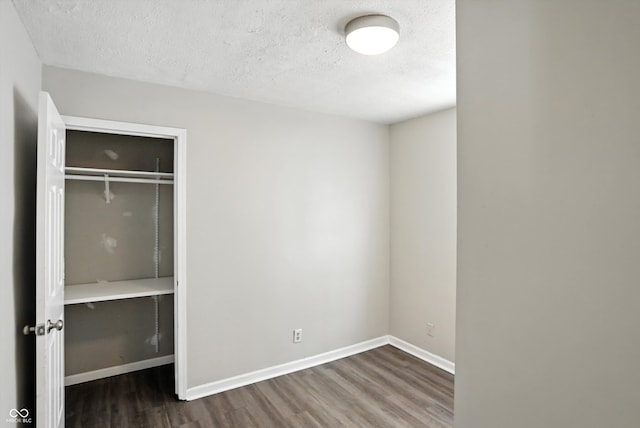 363 N 19th Ave, Beech Grove, IN 46107 - unfurnished bedroom featuring wood finished floors, a textured ceiling, and a closet
