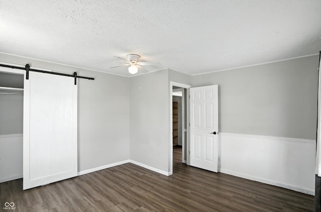 363 N 19th Ave, Beech Grove, IN 46107 - unfurnished bedroom with wood finished floors, a barn door, a textured ceiling, a ceiling fan, and a closet