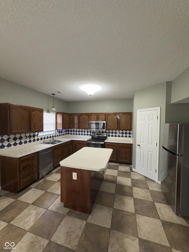 1881 Harvest Meadow Dr, Greenwood, IN 46143 - kitchen featuring stainless steel appliances, tasteful backsplash, light countertops, a center island, and a textured ceiling