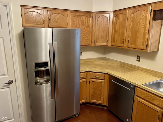 7410 Crickwood Pl, Indianapolis, IN 46268 - kitchen featuring stainless steel appliances, light countertops, dark wood-style floors, and brown cabinetry