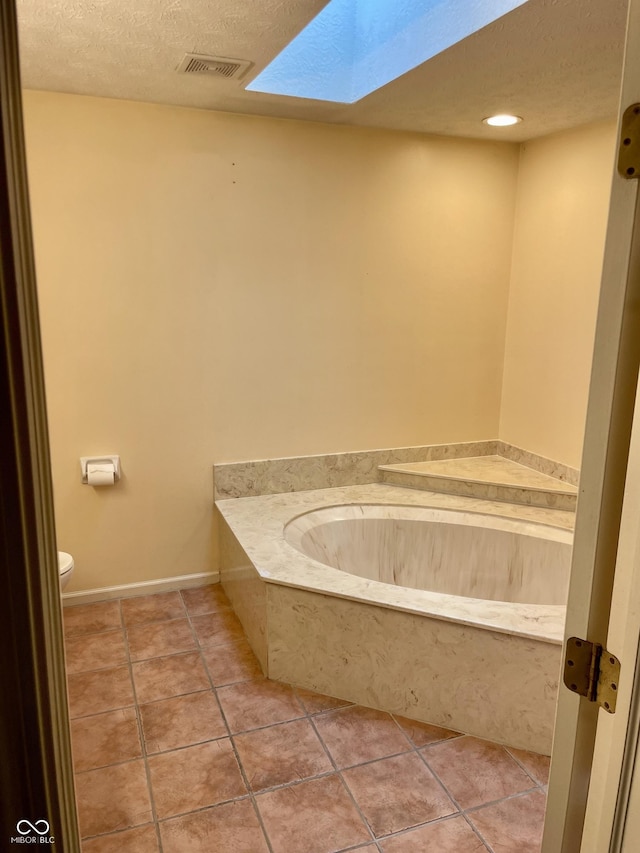 7410 Crickwood Pl, Indianapolis, IN 46268 - bathroom with a skylight, a garden tub, a textured ceiling, and tile patterned floors
