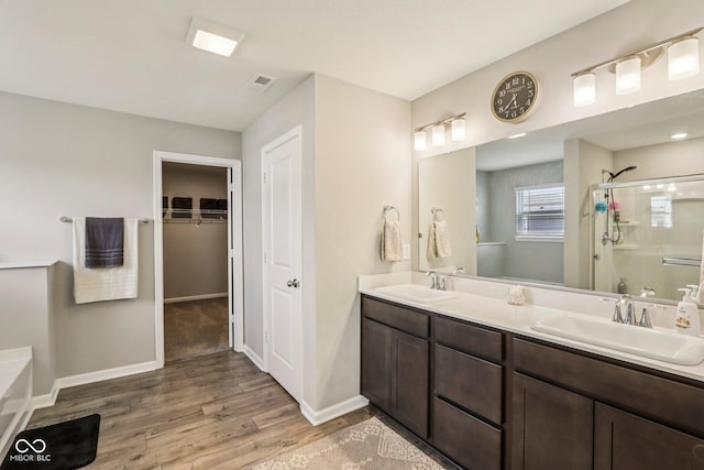 338 Limerick Ln, Pendleton, IN 46064 - full bathroom featuring a shower stall, wood finished floors, double vanity, a bath, and a spacious closet