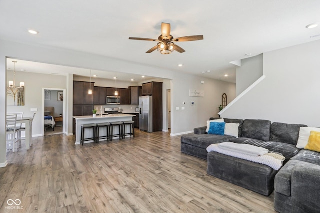 338 Limerick Ln, Pendleton, IN 46064 - living room featuring a ceiling fan, a chandelier, light wood finished floors, recessed lighting, and stairway