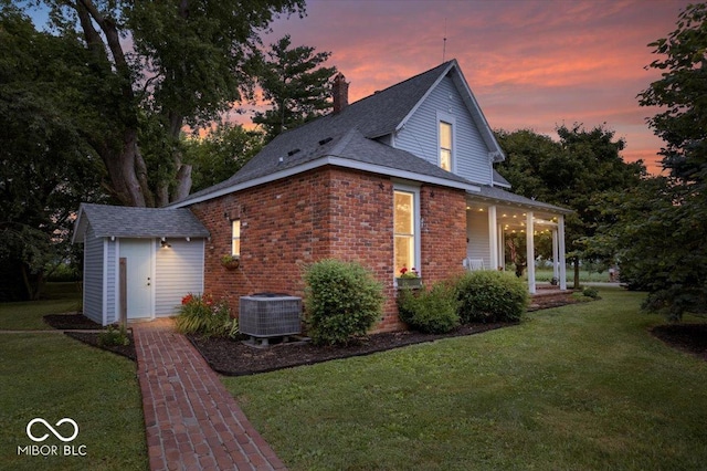 3160 S 50 E, Lebanon, IN 46052 - property exterior at dusk with a lawn, a storage unit, a chimney, and a porch
