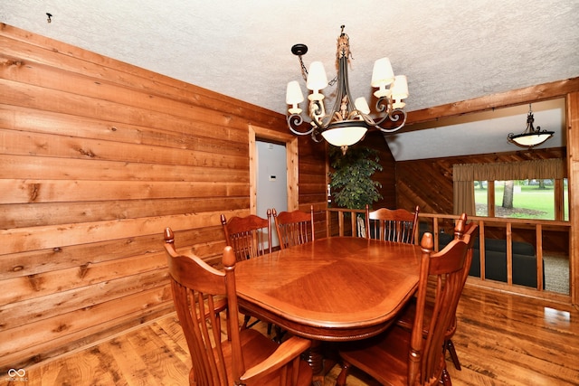 5202 Hill Valley Dr, Pittsboro, IN 46167 - dining space with wooden walls, wood finished floors, a chandelier, and a textured ceiling