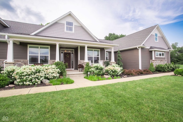 1434 Shootingstar Way, West Lafayette, IN 47906 - craftsman-style home featuring stone siding, covered porch, a front lawn, and a shingled roof