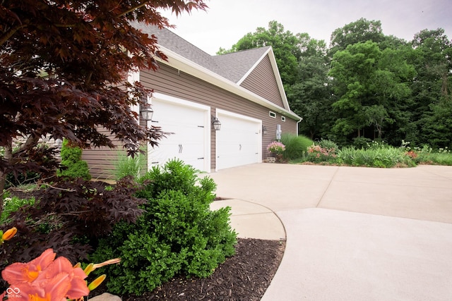 1434 Shootingstar Way, West Lafayette, IN 47906 - view of side of home with driveway, an attached garage, and roof with shingles
