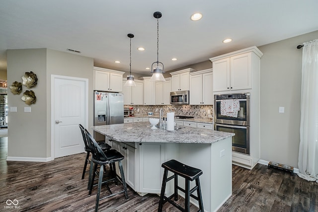 801 Oaklawn Dr, Westfield, IN 46074 - kitchen with appliances with stainless steel finishes, dark wood-type flooring, a kitchen island with sink, decorative backsplash, and recessed lighting