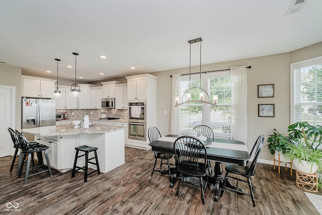 801 Oaklawn Dr, Westfield, IN 46074 - kitchen featuring appliances with stainless steel finishes, dark wood finished floors, white cabinets, a kitchen island with sink, and recessed lighting