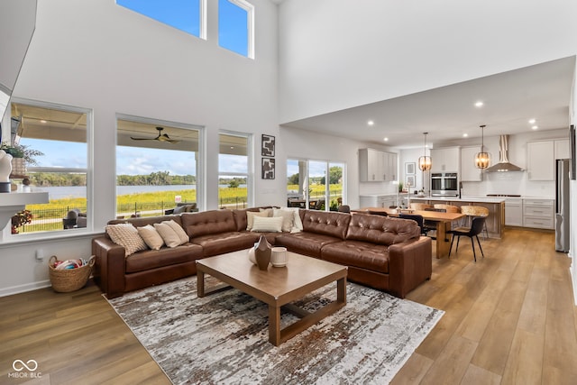 13644 Haven Cove Ln, Fishers, IN 46055 - living area featuring light wood-style floors, a ceiling fan, a towering ceiling, and recessed lighting