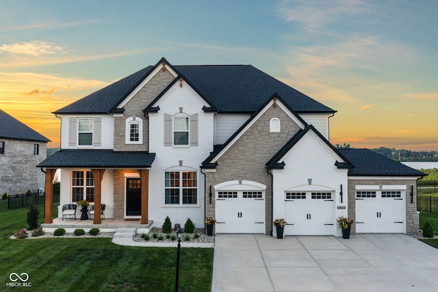 13644 Haven Cove Ln, Fishers, IN 46055 - french country style house with covered porch, stone siding, concrete driveway, and a shingled roof