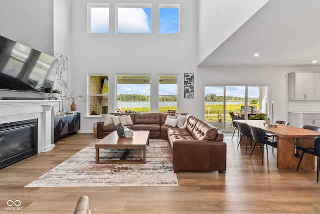 13644 Haven Cove Ln, Fishers, IN 46055 - living room featuring a high ceiling, wood finished floors, recessed lighting, and a glass covered fireplace