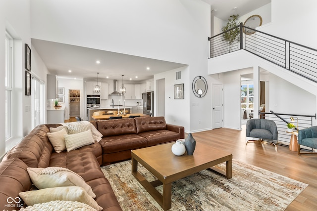 13644 Haven Cove Ln, Fishers, IN 46055 - living area featuring light wood-style floors, a high ceiling, recessed lighting, and stairs