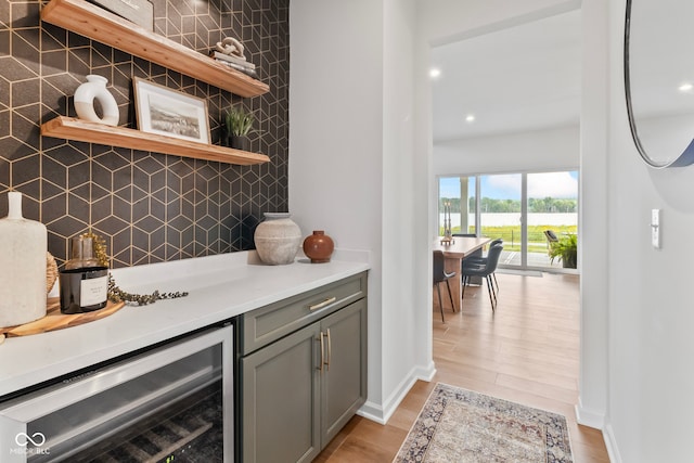 13644 Haven Cove Ln, Fishers, IN 46055 - indoor dry bar featuring beverage cooler, recessed lighting, light wood-type flooring, decorative backsplash, and a water view