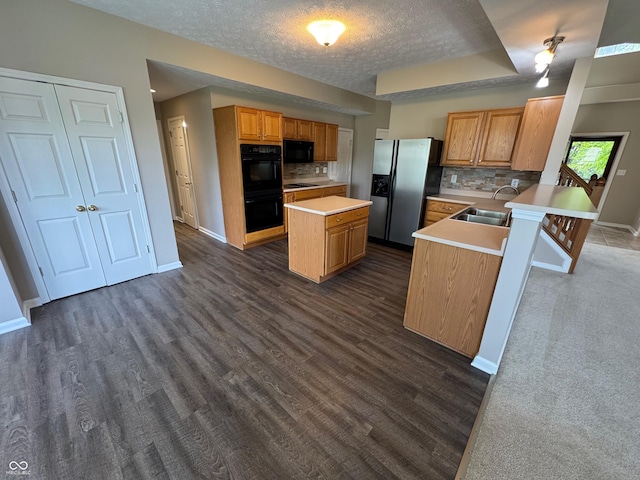 14520 Brackney Ln, Carmel, IN 46032 - kitchen featuring black appliances, a kitchen island, light countertops, decorative backsplash, and a textured ceiling