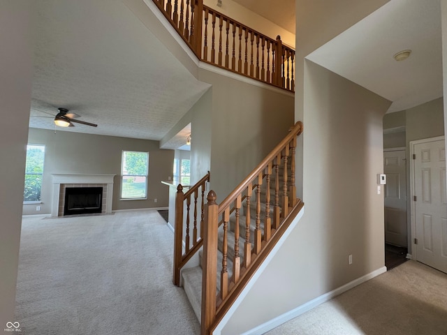 14520 Brackney Ln, Carmel, IN 46032 - staircase featuring carpet, ceiling fan, a fireplace, and a towering ceiling