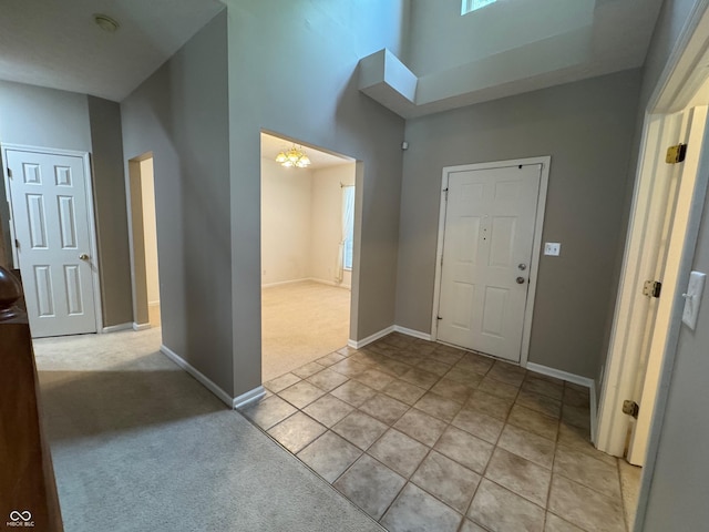 14520 Brackney Ln, Carmel, IN 46032 - entrance foyer with light colored carpet, a towering ceiling, light tile patterned floors, and a chandelier