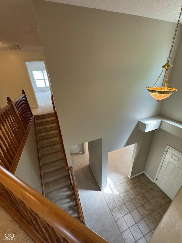 14520 Brackney Ln, Carmel, IN 46032 - staircase featuring a textured ceiling and tile patterned flooring