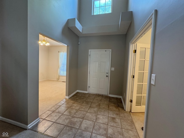 14520 Brackney Ln, Carmel, IN 46032 - entryway featuring a towering ceiling, a chandelier, light colored carpet, and light tile patterned floors
